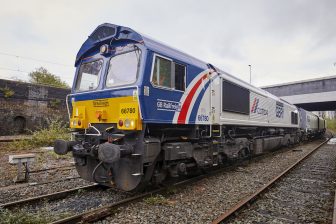 Three-quarter shot of train at CEMEX Hope Street in Salford which takes delivery of stone from Buxton with their own class 66 liveried locomotive and matching freight wagon hoppers