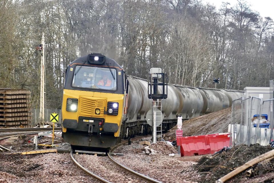 A heavy cement train leans into a curve heading out of Perth in Scotland