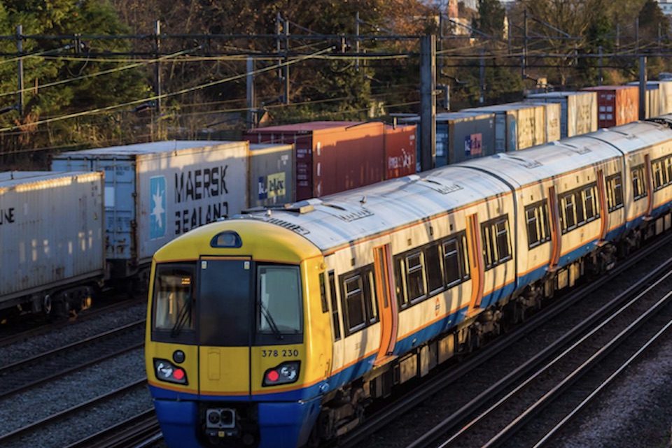 Freight and passenger train passing each other on tracks in London